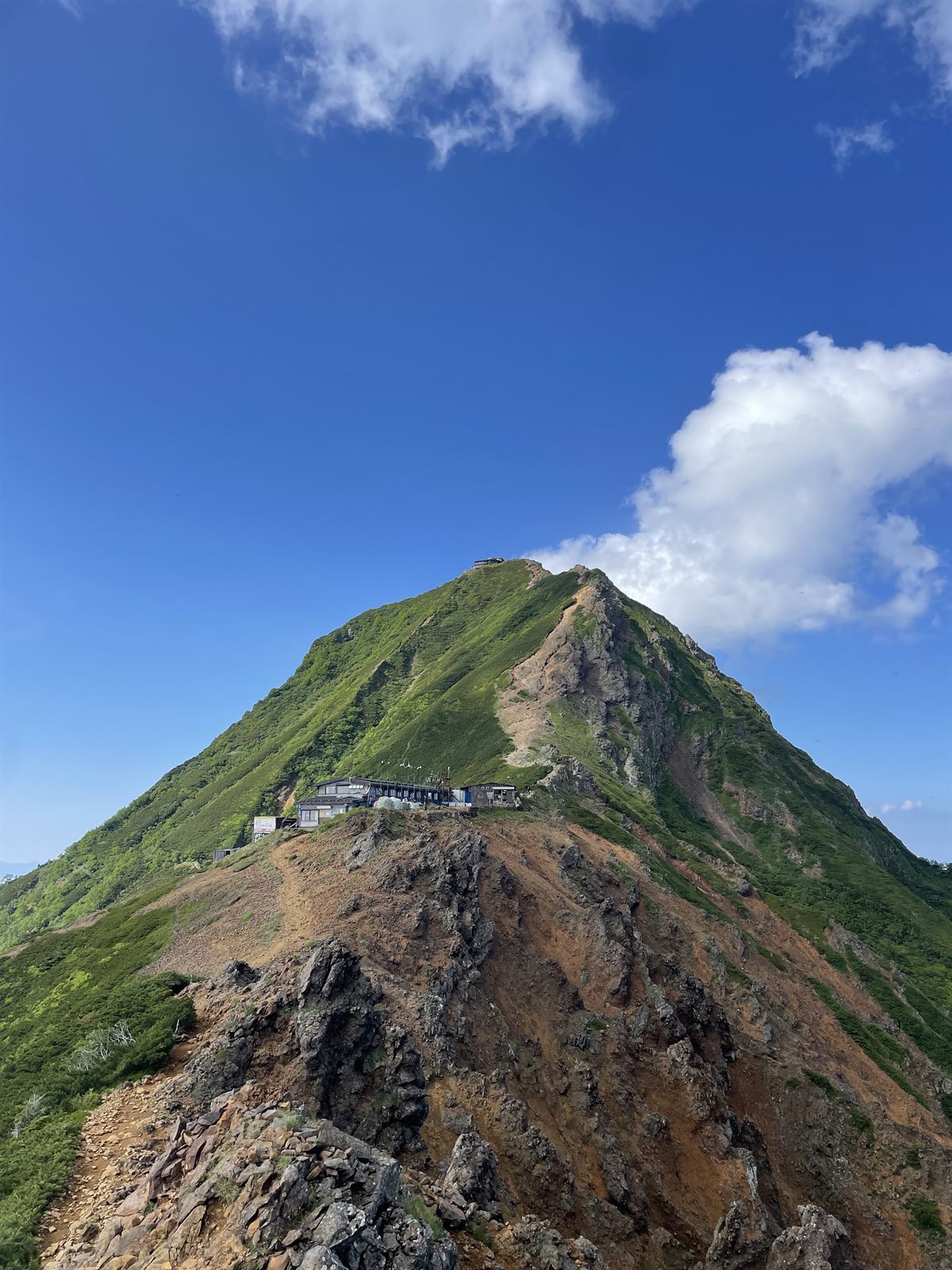 青空にそびえる赤岳の山頂